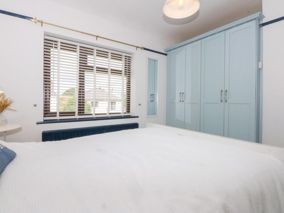 A bedroom with a bed and wardrobe at Fairfield in Llanbedrog