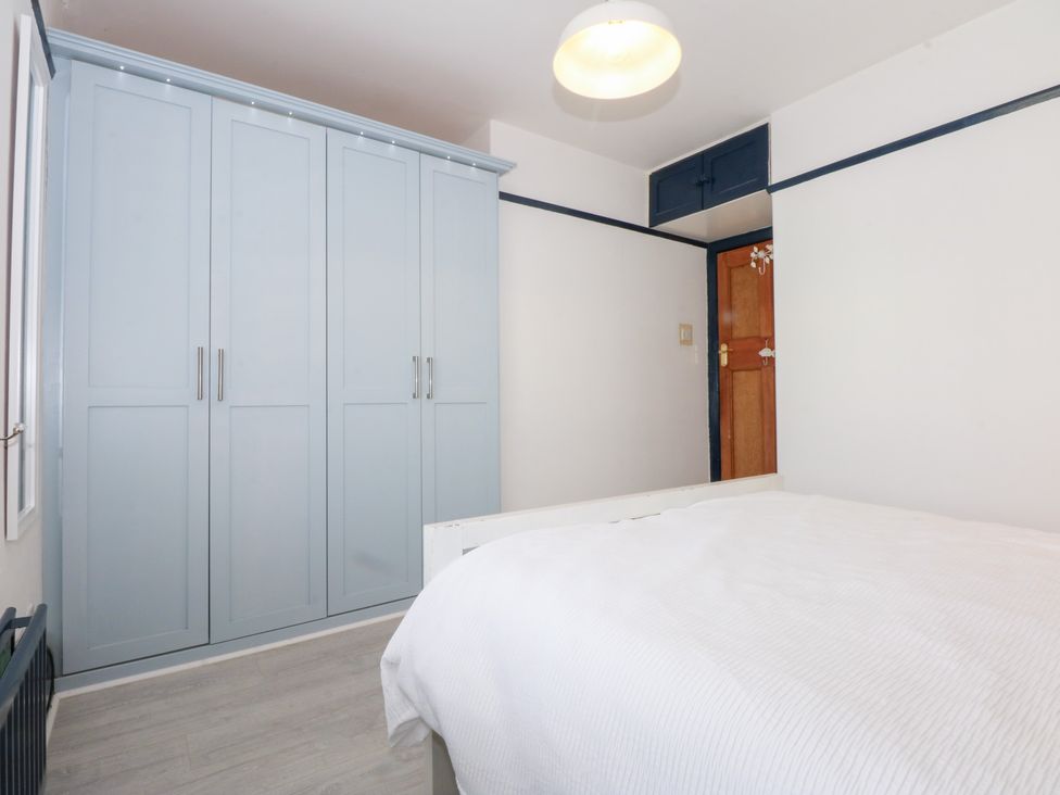 A bedroom with a wardrobe and bed at Fairfield in Llanbedrog