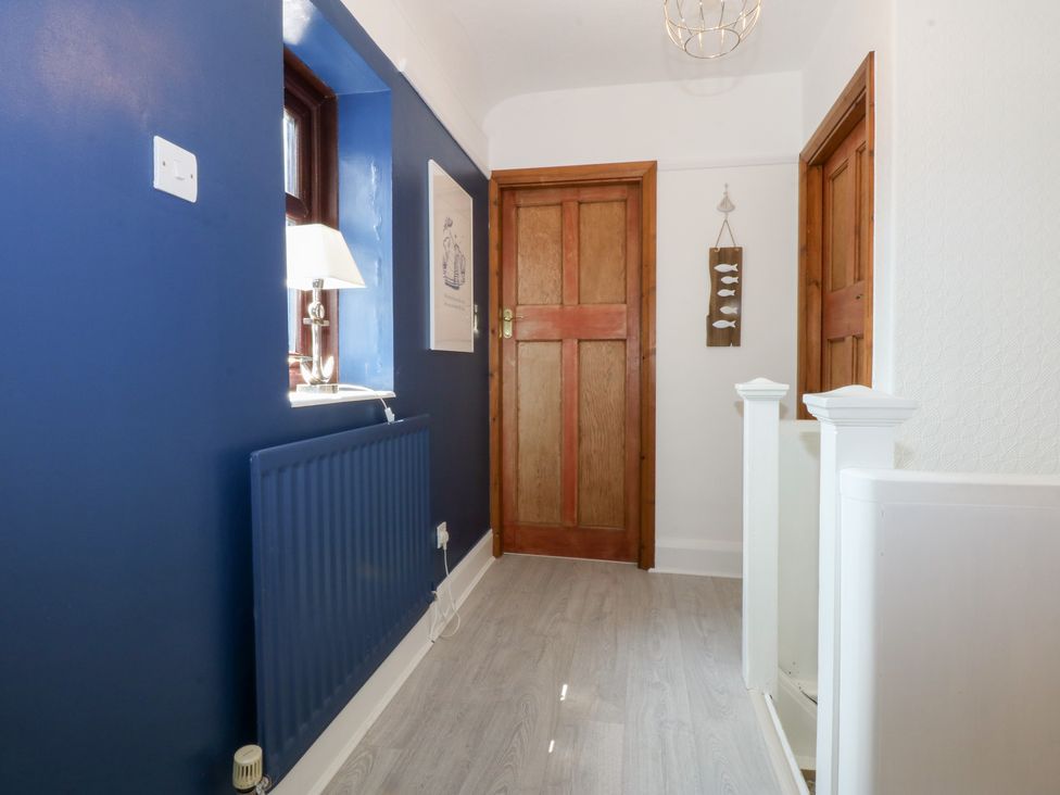 A hallway with a radiator and lamp at Fairfield in Llanbedrog