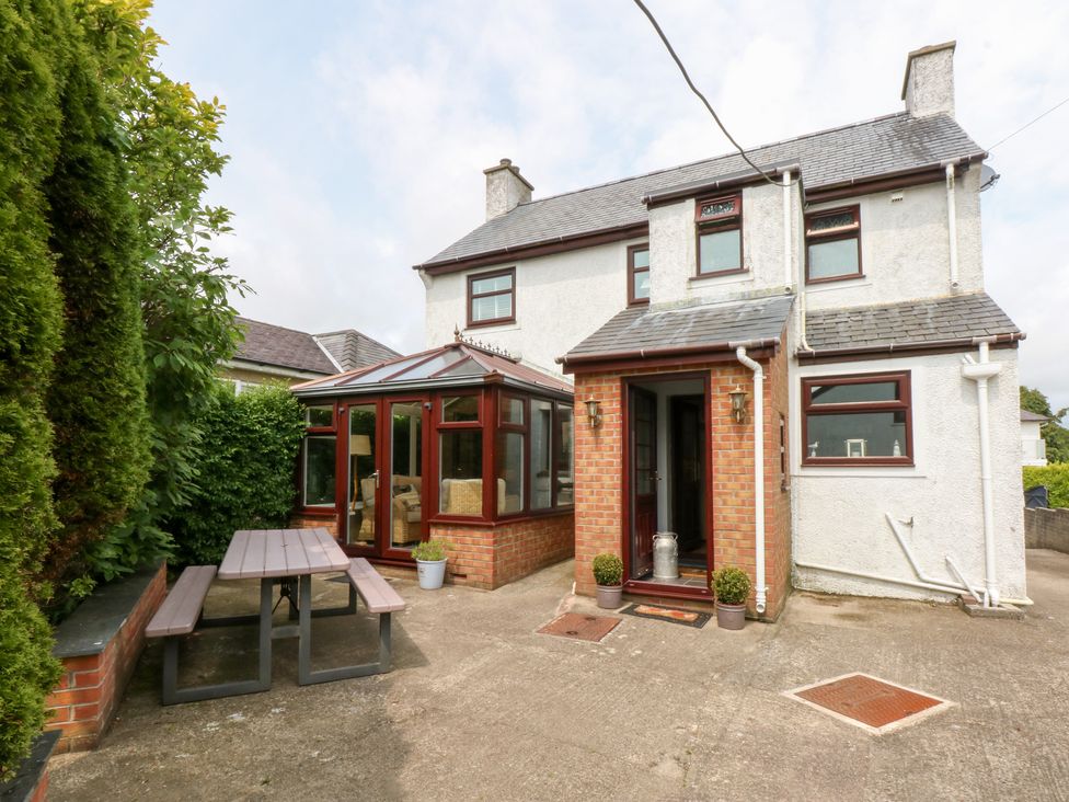 An outdoor area with a house and conservatory at Fairfield in Llanbedrog