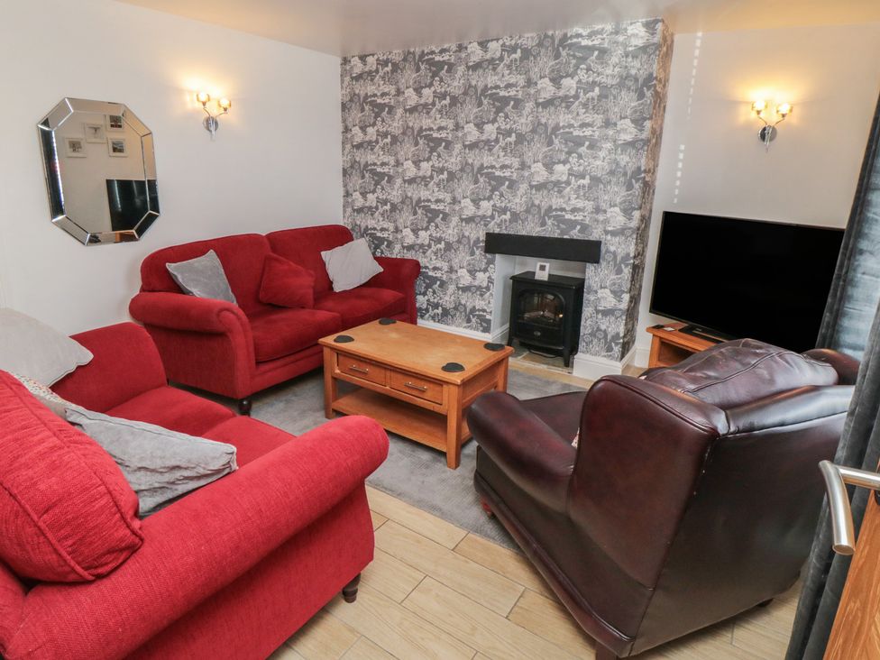 A living room with sofas and a television at Bluebell Cottage in Flamborough
