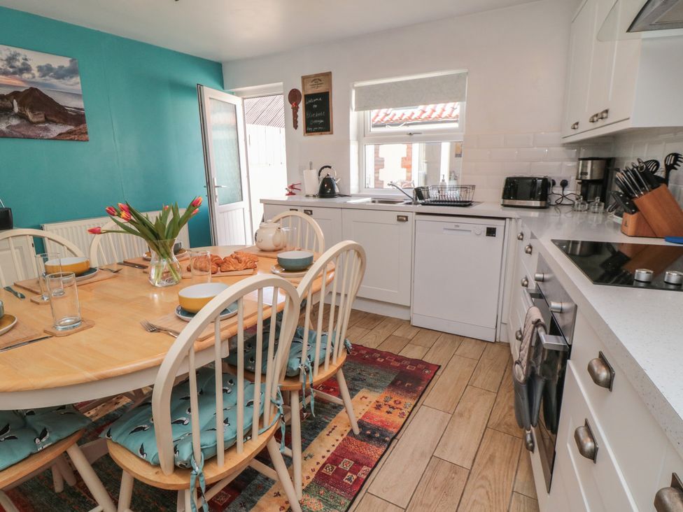 A kitchen with a dining table and chairs at Bluebell Cottage in Flamborough