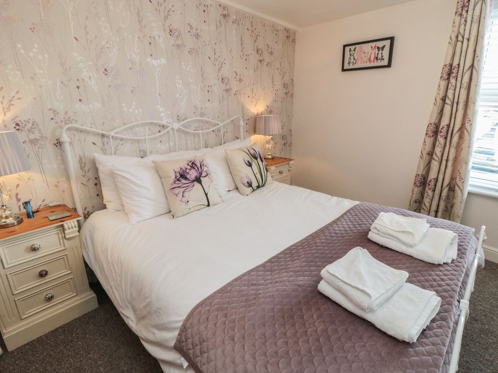 A bedroom with a bed and nightstand at Bluebell Cottage in Flamborough