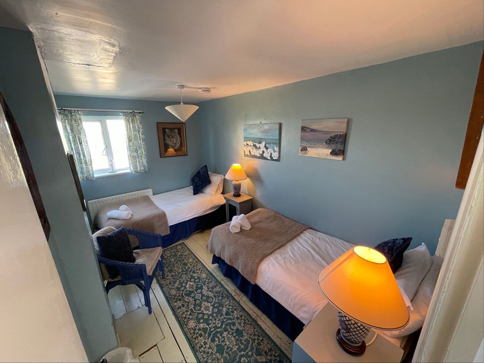A bedroom with two beds and artwork on the walls at 11 Penygroes in Llanddeusant