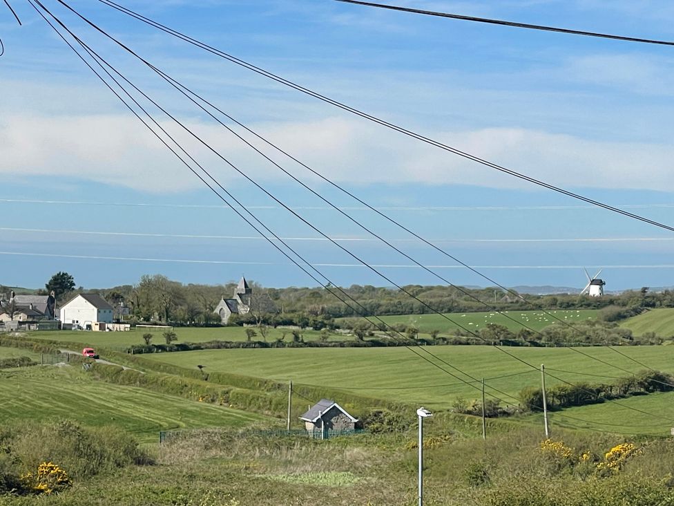 A landscape view with fields and a windmill at 11 Penygroes in Llanddeusant