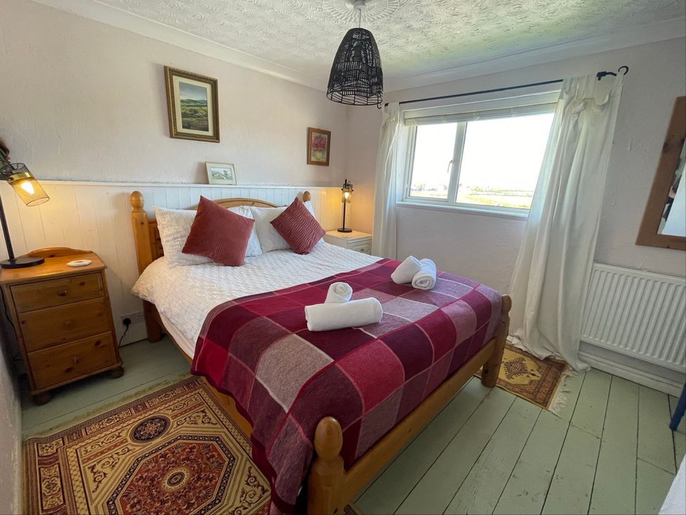 A bedroom with a double bed and furniture at 11 Penygroes in Llanddeusant