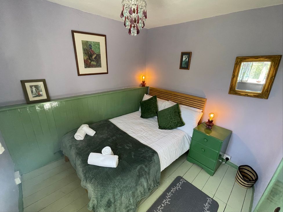 A bedroom with a bed and two lamps at 11 Penygroes in Llanddeusant