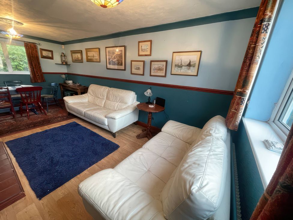 A living room with sofas and a dining area at 11 Penygroes in Llanddeusant