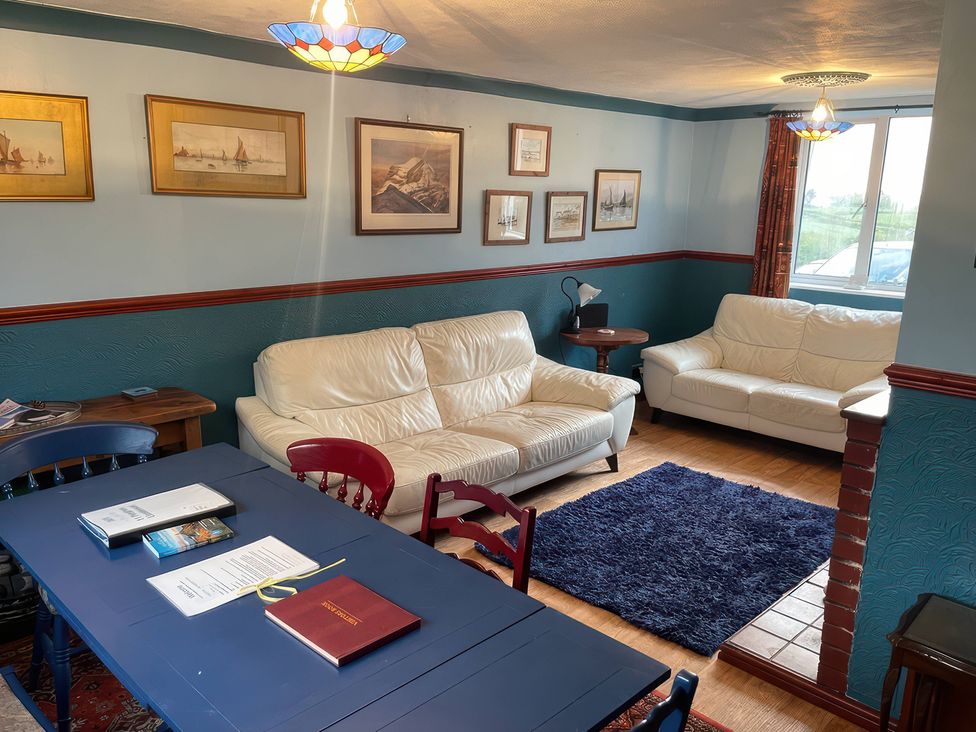 A living room with sofas and a table at 11 Penygroes in Llanddeusant