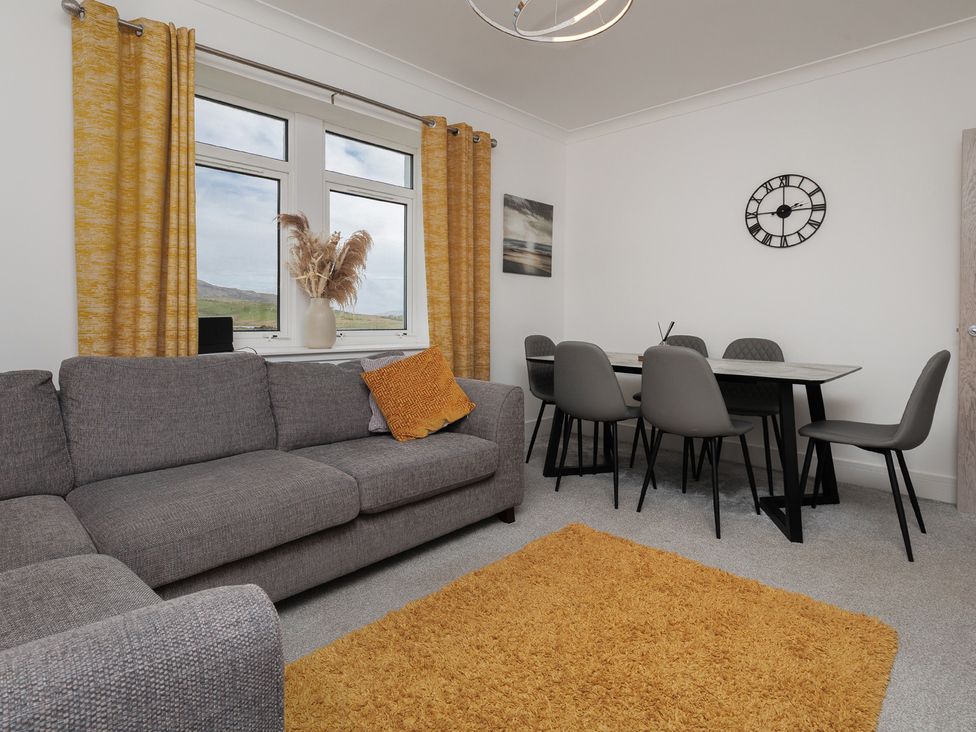 A living room with a sofa and dining table at Dun Buidhe South Boisdale near Daliburgh Isle Of South Uist