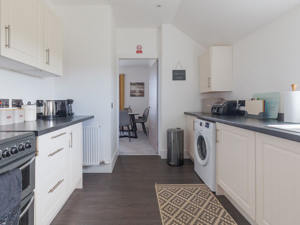 A kitchen with appliances and a washing machine at Dun Buidhe South Boisdale near Daliburgh Isle Of South Uist