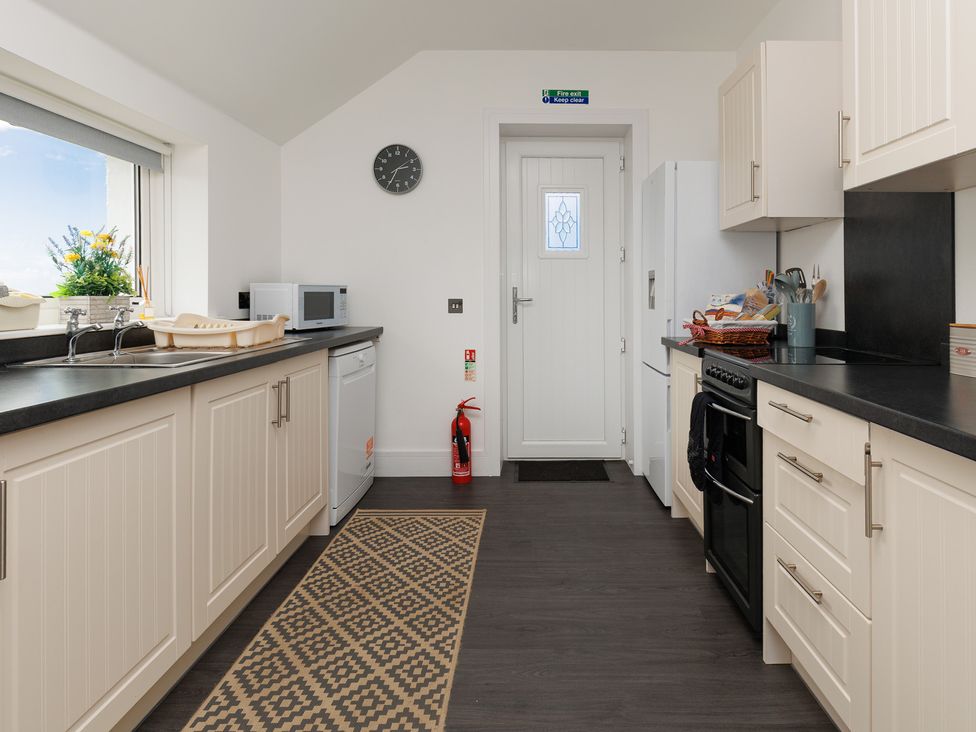 A kitchen with a sink and appliances at Dun Buidhe in South Boisdale near Daliburgh, Isle Of South Uist