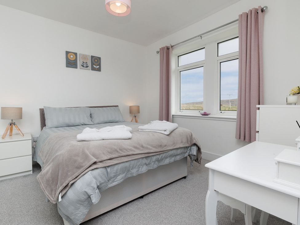 A bedroom with a bed and two nightstands at Dun Buidhe South Boisdale near Daliburgh Isle Of South Uist