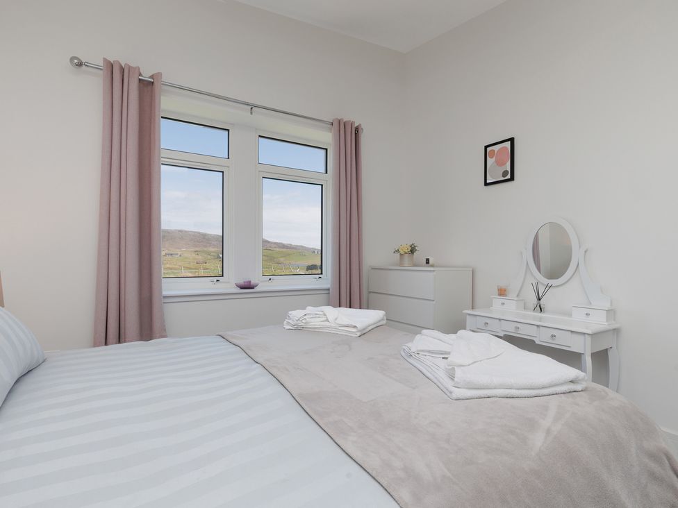 A bedroom with a bed and dresser at Dun Buidhe in South Boisdale near Daliburgh, Isle Of South Uist