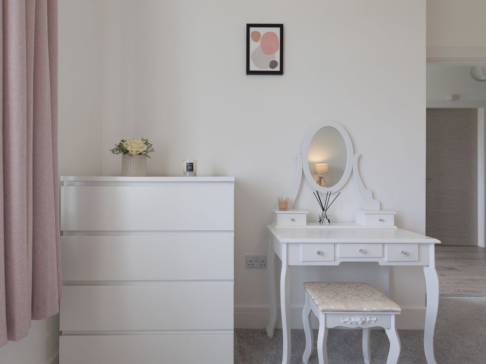 A bedroom with a dresser and vanity table at Dun Buidhe South Boisdale near Daliburgh Isle Of South Uist