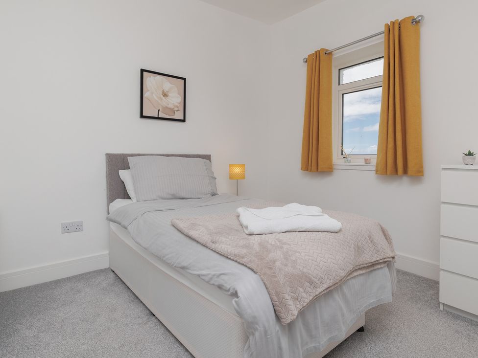 A bedroom with a bed and bedside lamp at Dun Buidhe South Boisdale near Daliburgh, Isle Of South Uist
