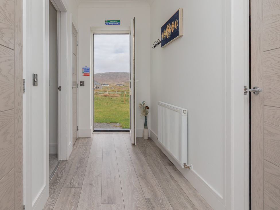 A hallway with a door and radiator at Dun Buidhe, South Boisdale near Daliburgh, Isle Of South Uist