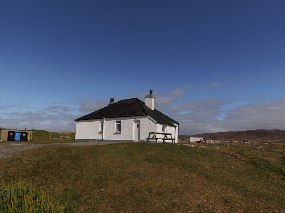A house with a bench and garbage bins in South Boisdale near Daliburgh, Isle Of South Uist