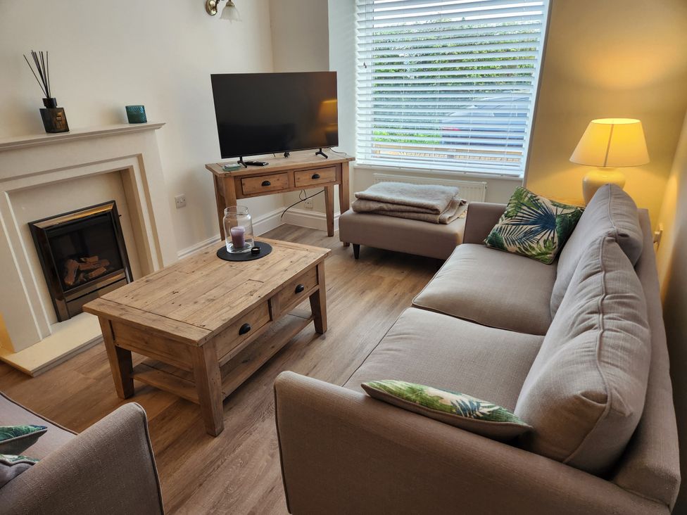 A living room with a sofa and television at 8 Arvonia Terrace Cricieth