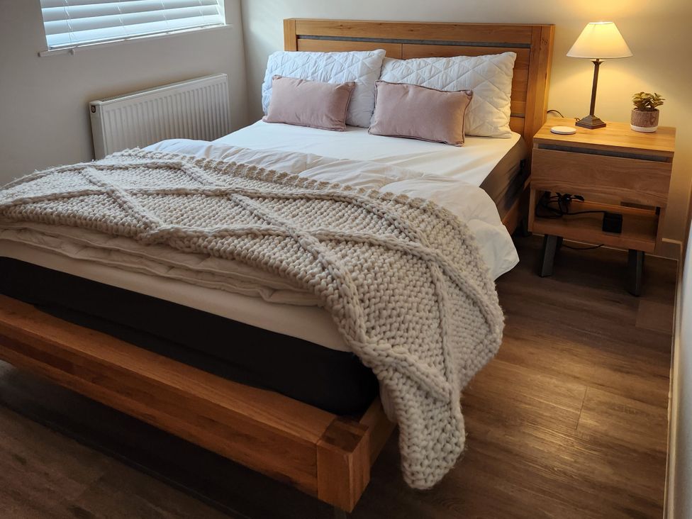 A bedroom with a bed and bedside table at 8 Arvonia Terrace in Cricieth