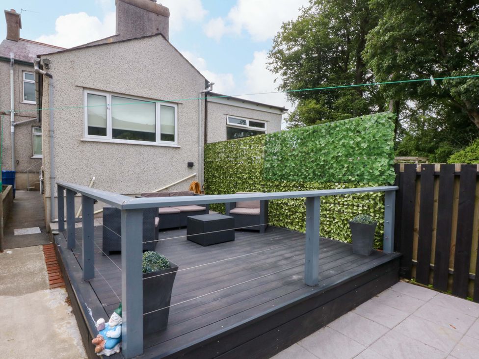 An outdoor area with a wooden deck and furniture at Y Berth in Caernarfon