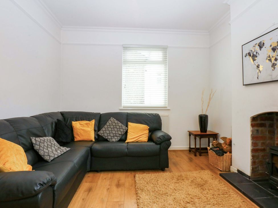 A living room with a sofa and decorative items at Y Berth in Caernarfon