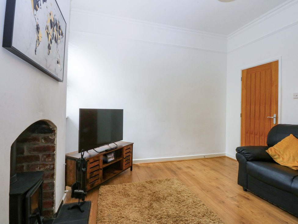 A living room with a sofa and a television at Y Berth in Caernarfon