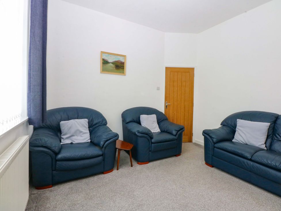 A living room with two sofas and a painting at Y Berth in Caernarfon