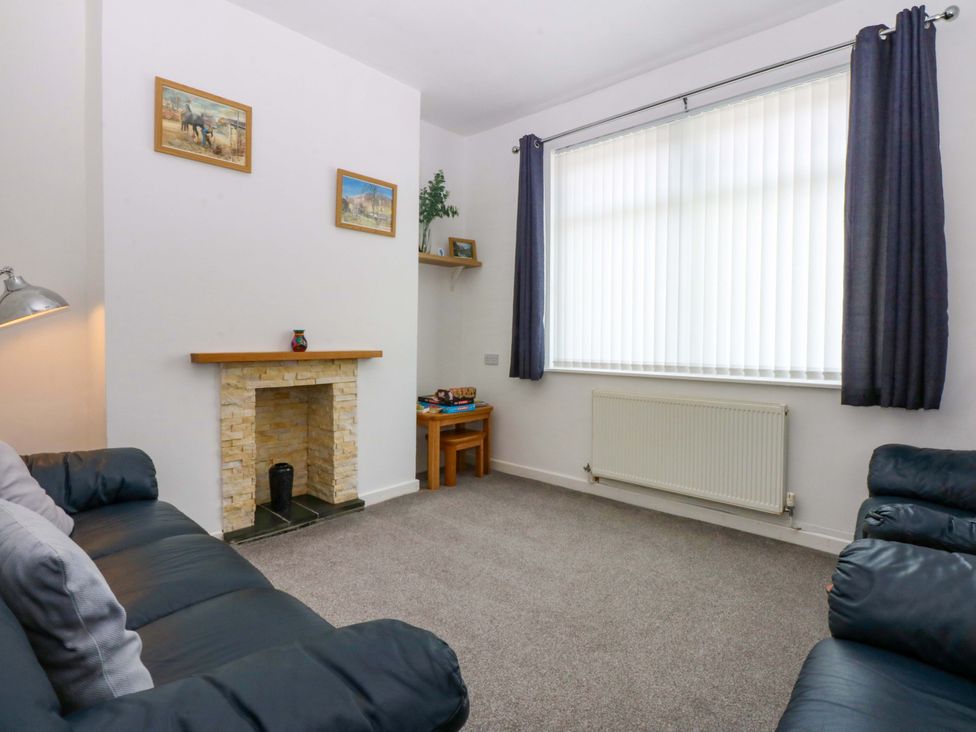 A living room with a sofa and fireplace at Y Berth in Caernarfon