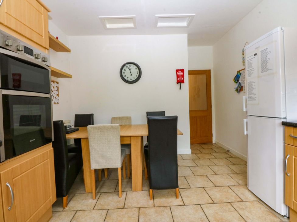 A kitchen with a table and chairs at Y Berth in Caernarfon