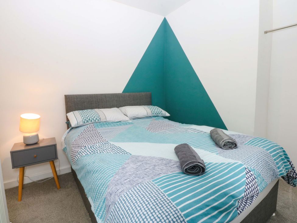A bedroom with a bed and nightstand at Y Berth in Caernarfon