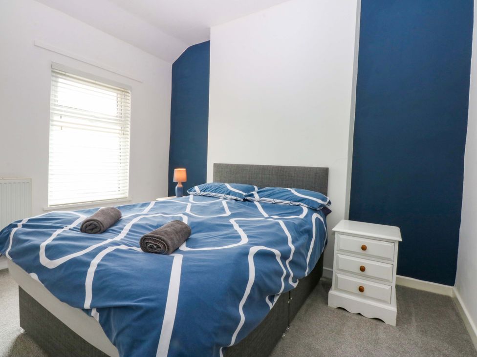A bedroom with a bed and bedside table at Y Berth in Caernarfon