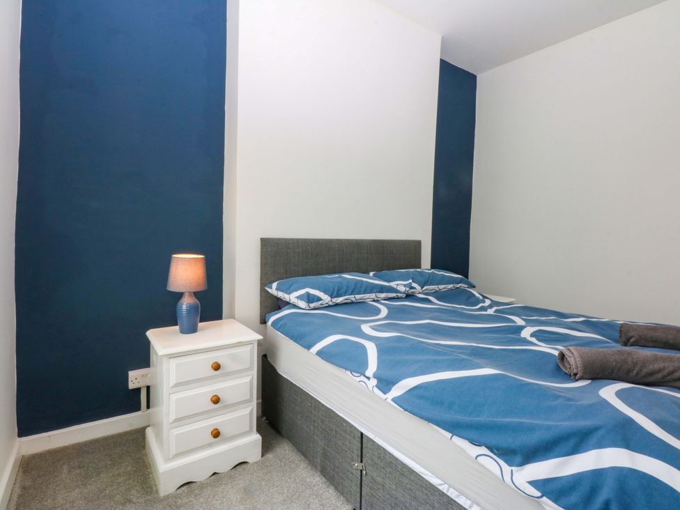 A bedroom with a bed and a bedside table at Y Berth in Caernarfon