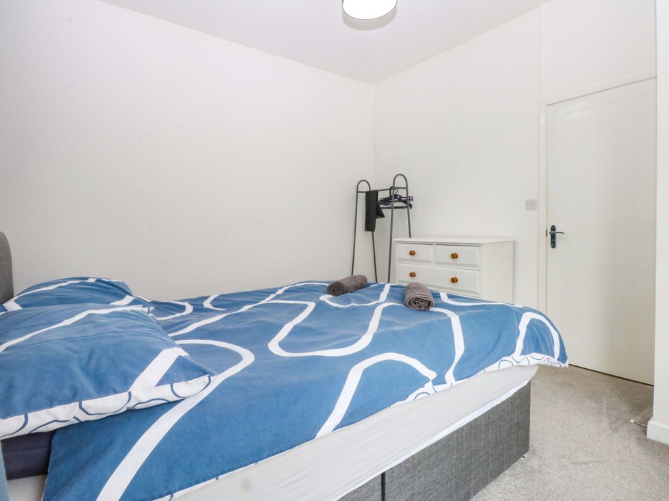 A bedroom with a bed and dresser at Y Berth in Caernarfon
