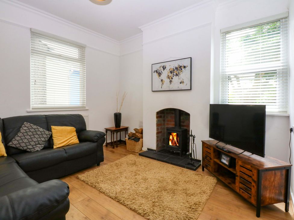 A living room with a fireplace and television at Y Berth in Caernarfon