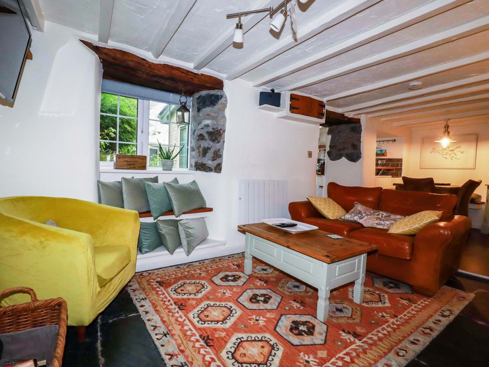 A living room with a sofa and coffee table at Woodview in Looe