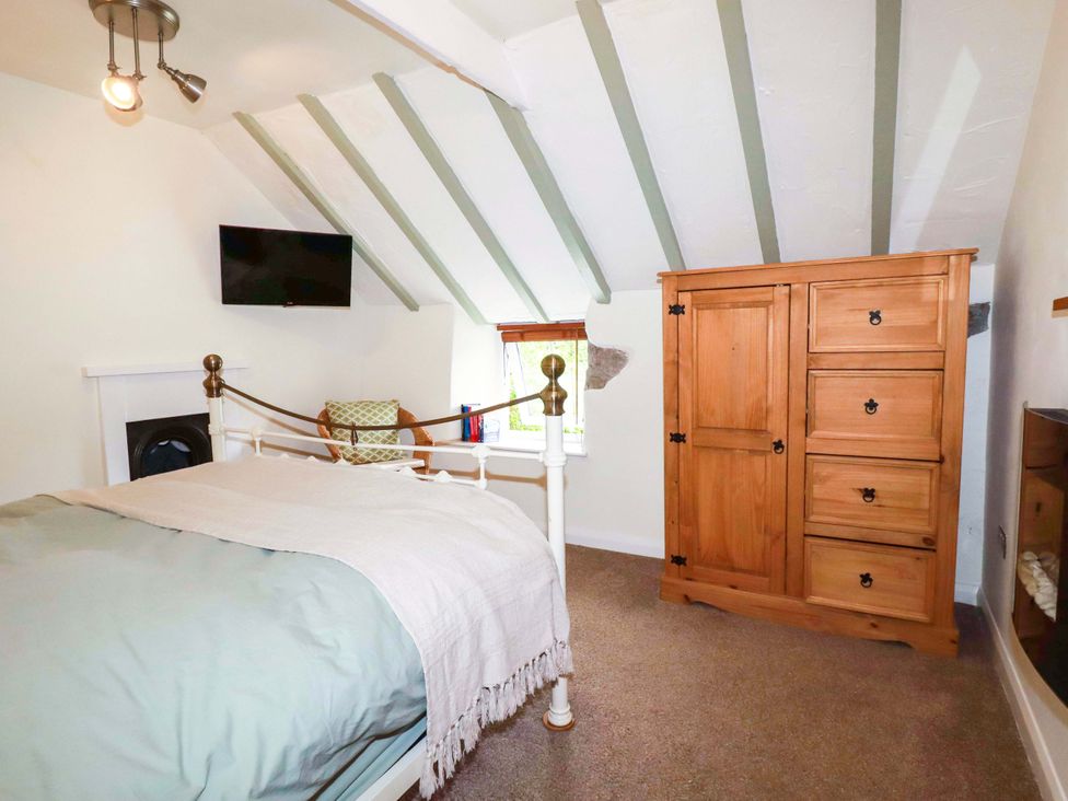 A bedroom with a bed and wardrobe at Woodview in Looe