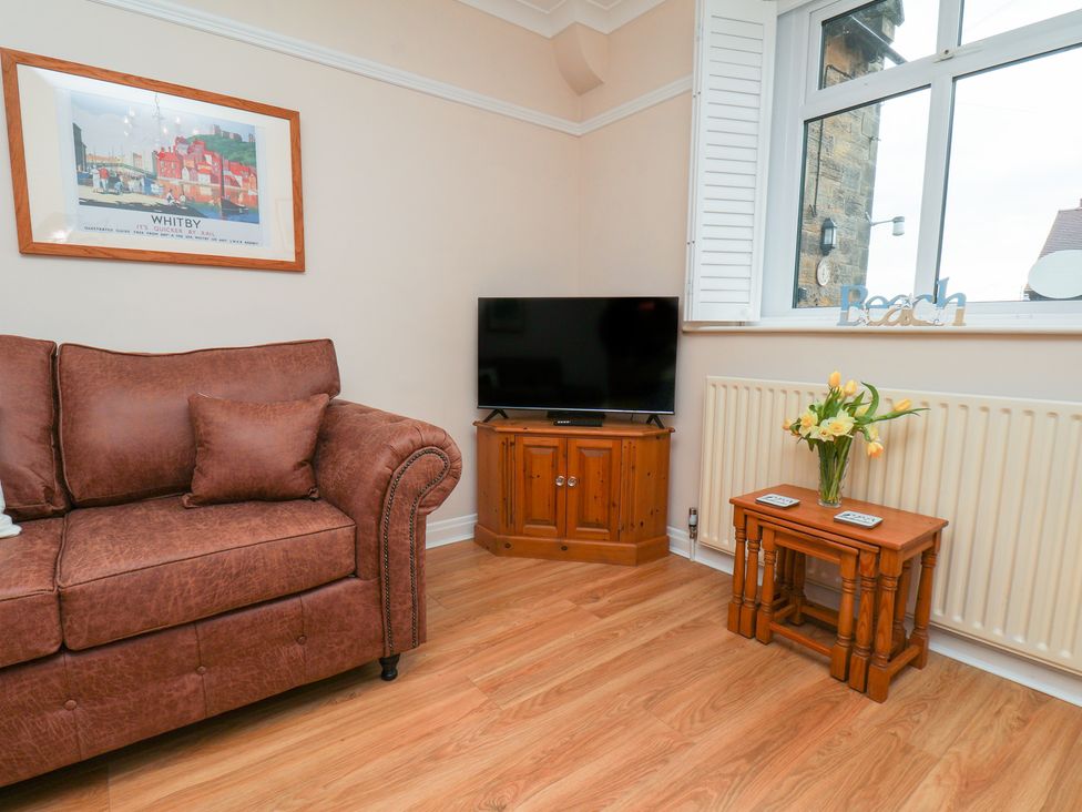 A living room with a sofa and television at Maypole Cottage in Fylingthorpe