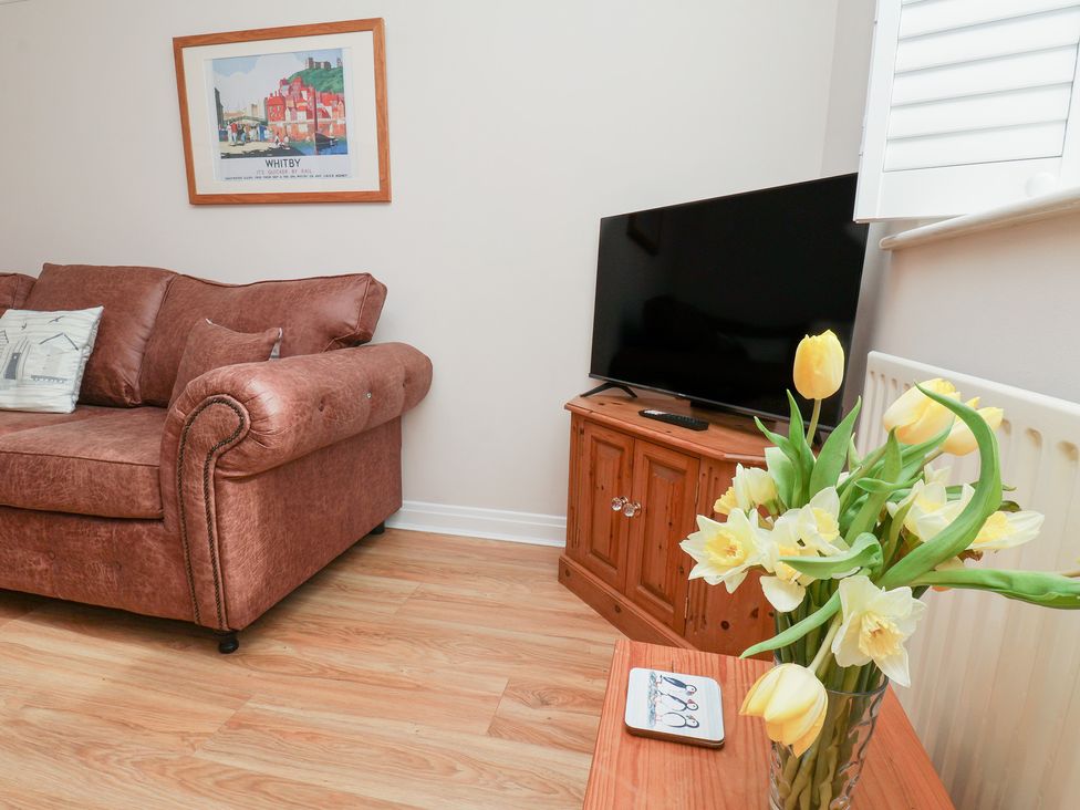 A living room with a sofa and a television at Maypole Cottage in Fylingthorpe
