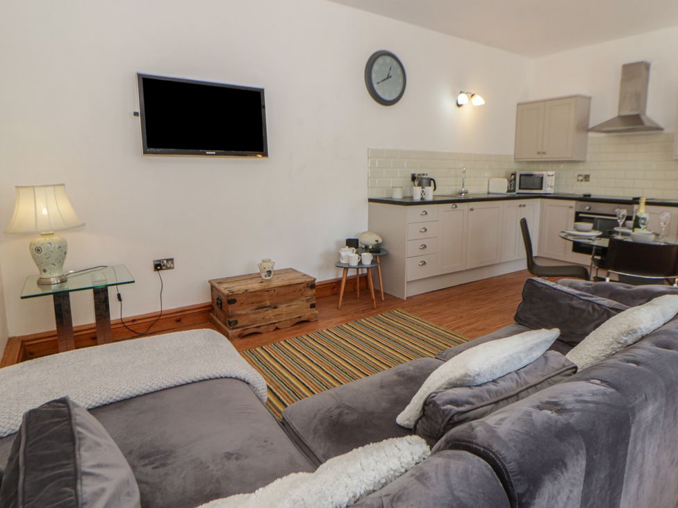 A living room with a kitchen area at Swallows Retreat in Tenby