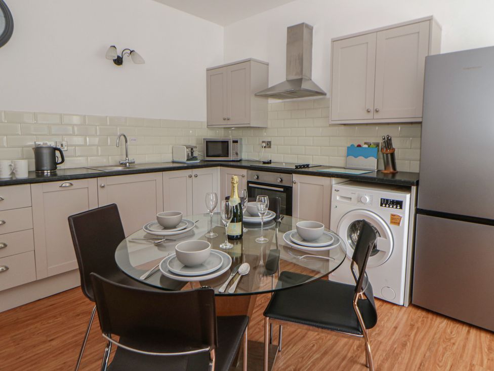 A kitchen with a table and chairs at Swallows Retreat in Tenby