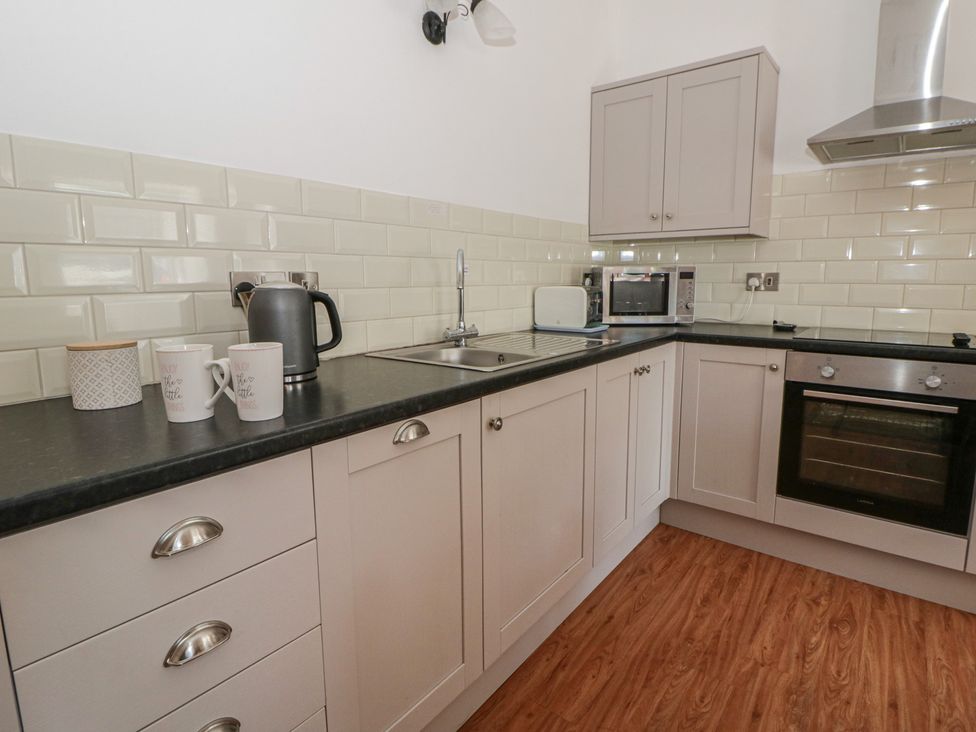 A kitchen with a sink and appliances at Swallows Retreat in Tenby