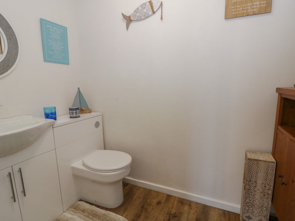 A bathroom with a sink and toilet at Swallows Retreat in Tenby