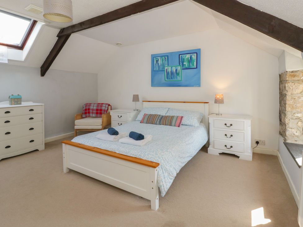 A bedroom with a bed and drawer units at Swallows Retreat in Tenby