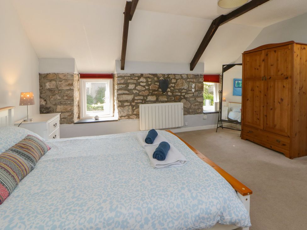 A bedroom with a bed and window at Swallows Retreat in Tenby