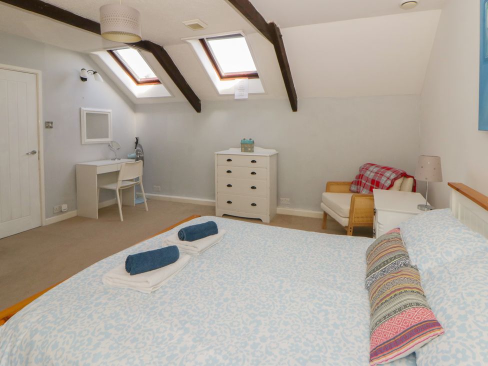 A bedroom with a bed and desk at Swallows Retreat in Tenby