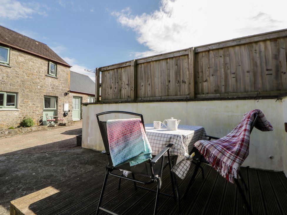 An outdoor seating area with table and chairs at Swallows Retreat in Tenby
