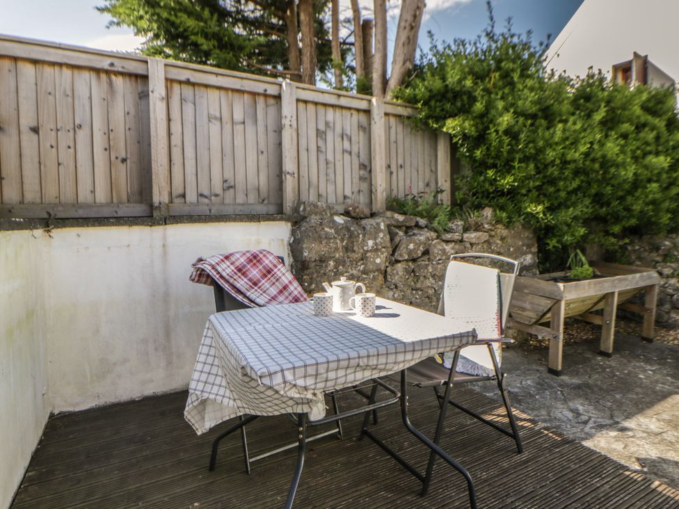 An outdoor seating area with a table and chairs at Swallows Retreat in Tenby