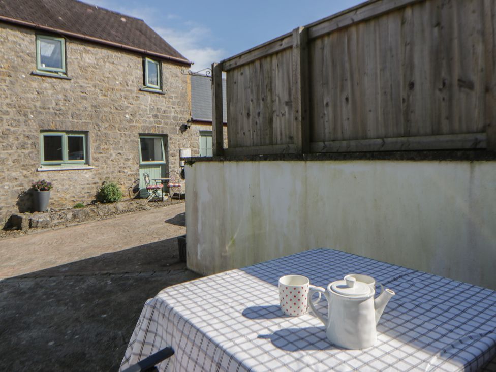 A table with a tea pot and mug in the garden at Swallows Retreat in Tenby