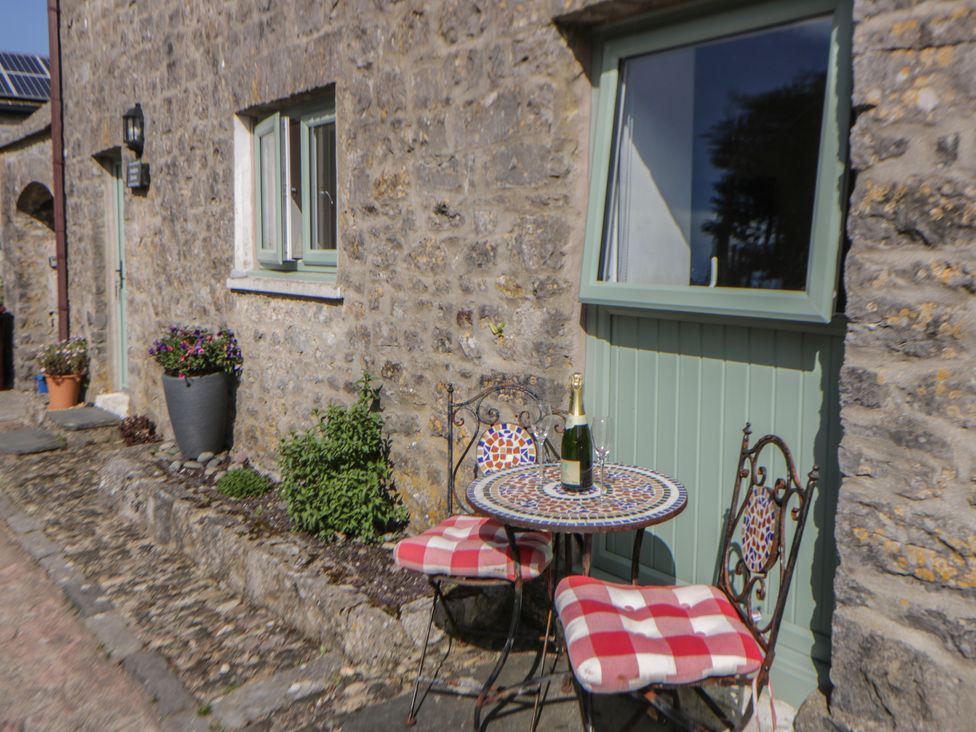 An outdoor seating area with a bistro table and chairs at Swallows Retreat in Tenby